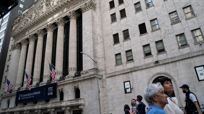 Pedestrians pass the New York Stock Exchange, May 5, 2022, in the Manhattan borough of New York.