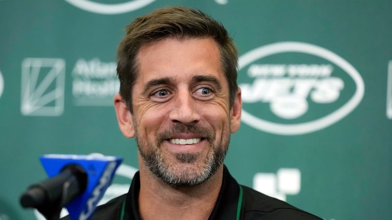 FILE - New York Jets' quarterback Aaron Rodgers smiles during an NFL football news conference...