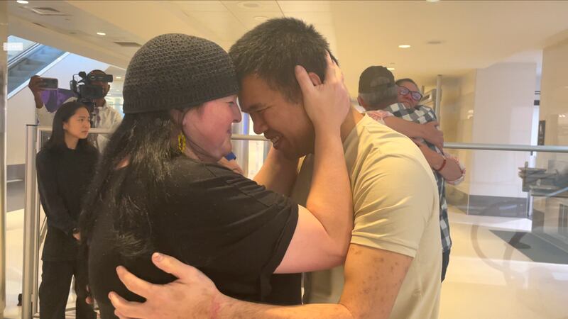 Andy Huynh, left, and Alex Drueke, far right, are seen hugging their loved ones after arriving...