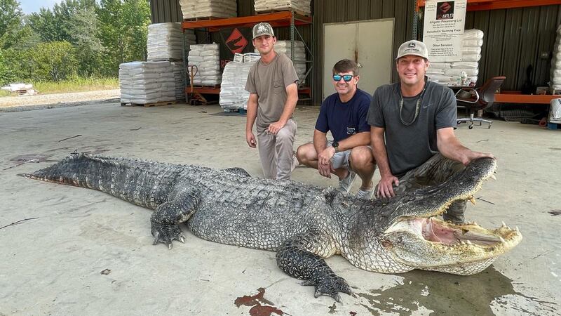 The department identified the hunters who made the catch as Tanner White (left), Don Woods...
